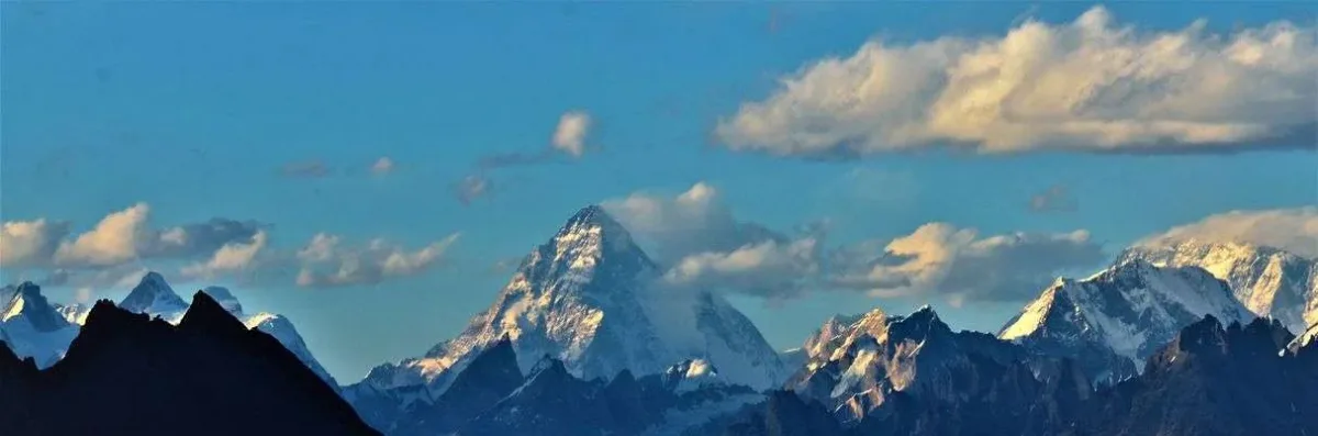 The pyramid of K2 rises above the Karakoram skyline at dawn, the panorama seen from the Barah Broq trek K2 viewpoint on Moses Peak in Pakistan