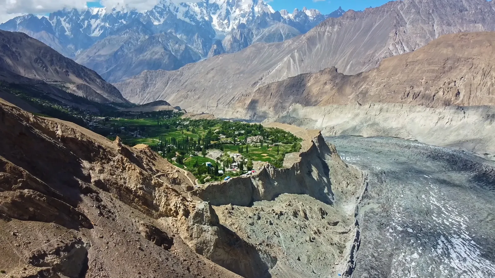 Aerial view of the green Hopar Valley in Nagar with the grey Hopar (Bualtar) Glacier curling below jagged Karakoram peaks