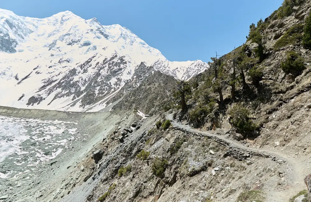 Denai kem asas di bawah dinding salji luas Rakaposhi (7,788 m)