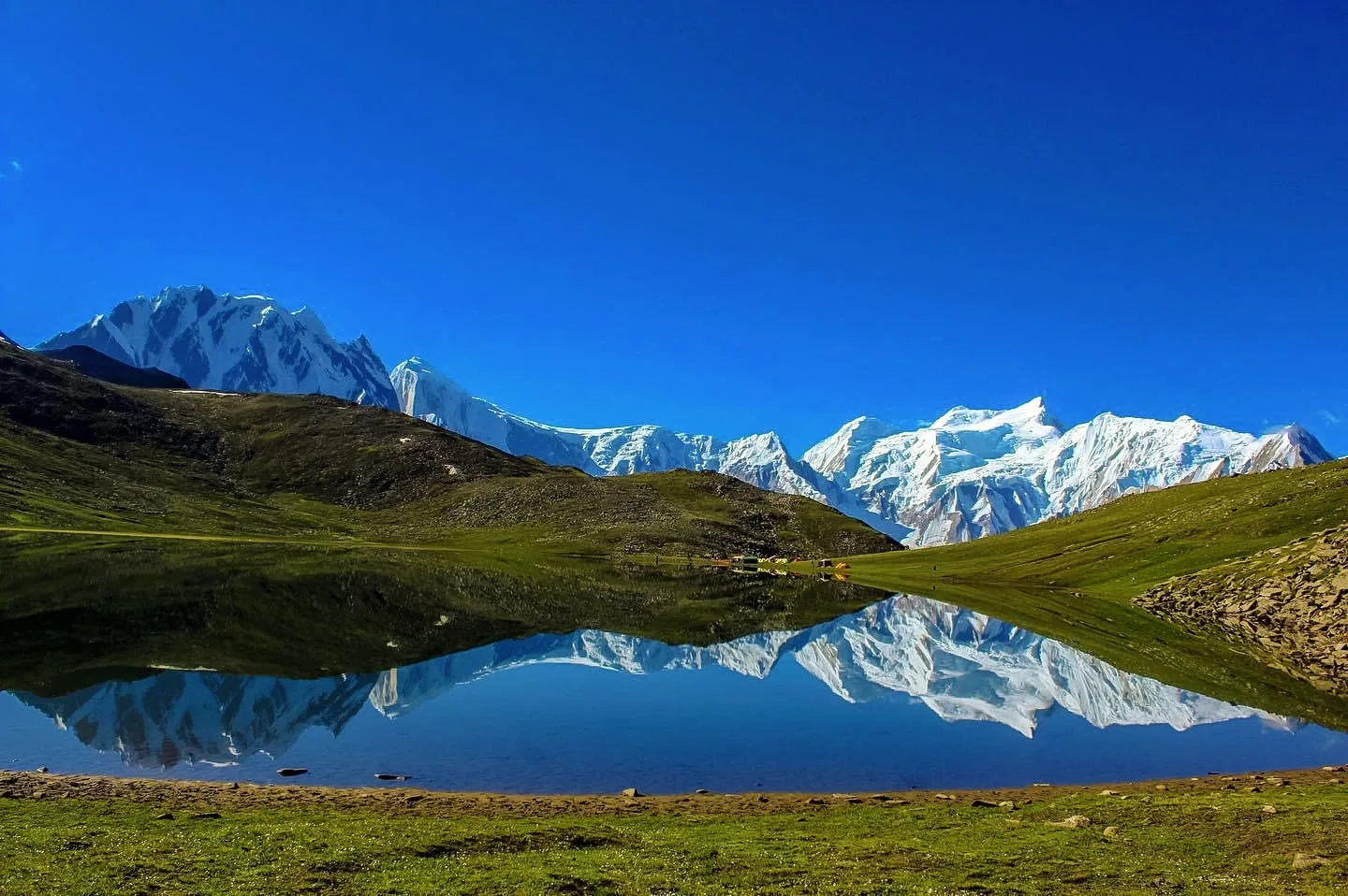 Snow peaks of the Spantik group mirrored in the still water of Rush Lake, one of the highest alpine lakes in the world, above Hopar in Nagar
