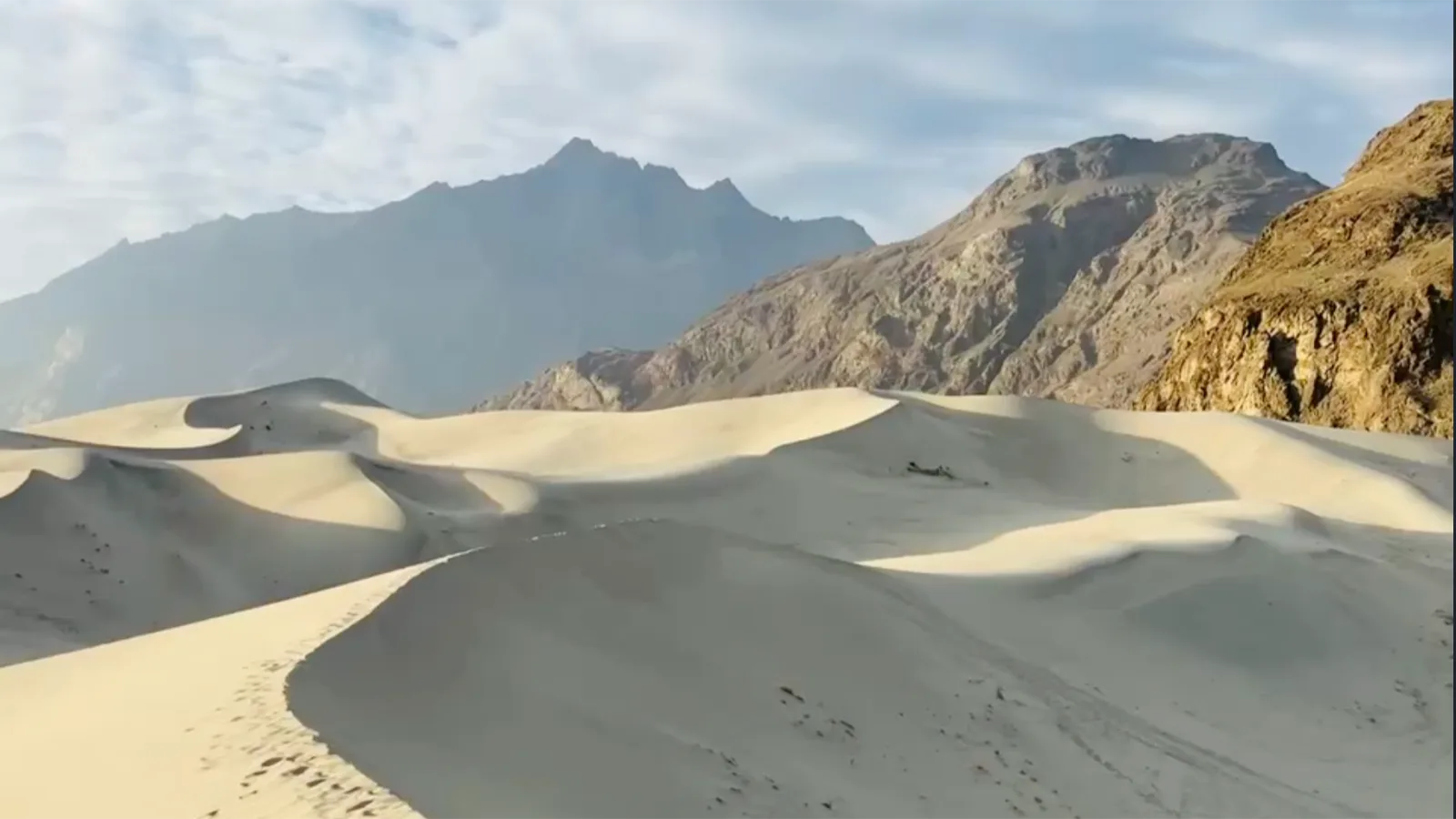 Golden sand dunes of the Sarfaranga cold desert near Skardu with the Karakoram mountains behind, Gilgit-Baltistan
