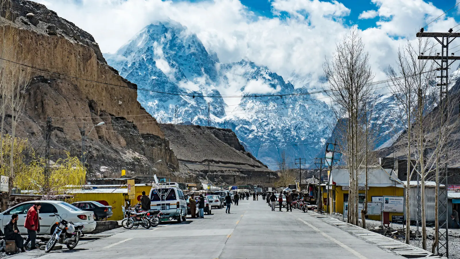 The main street of Sost, the last town in Upper Hunza before the China border, with shops and snow peaks behind