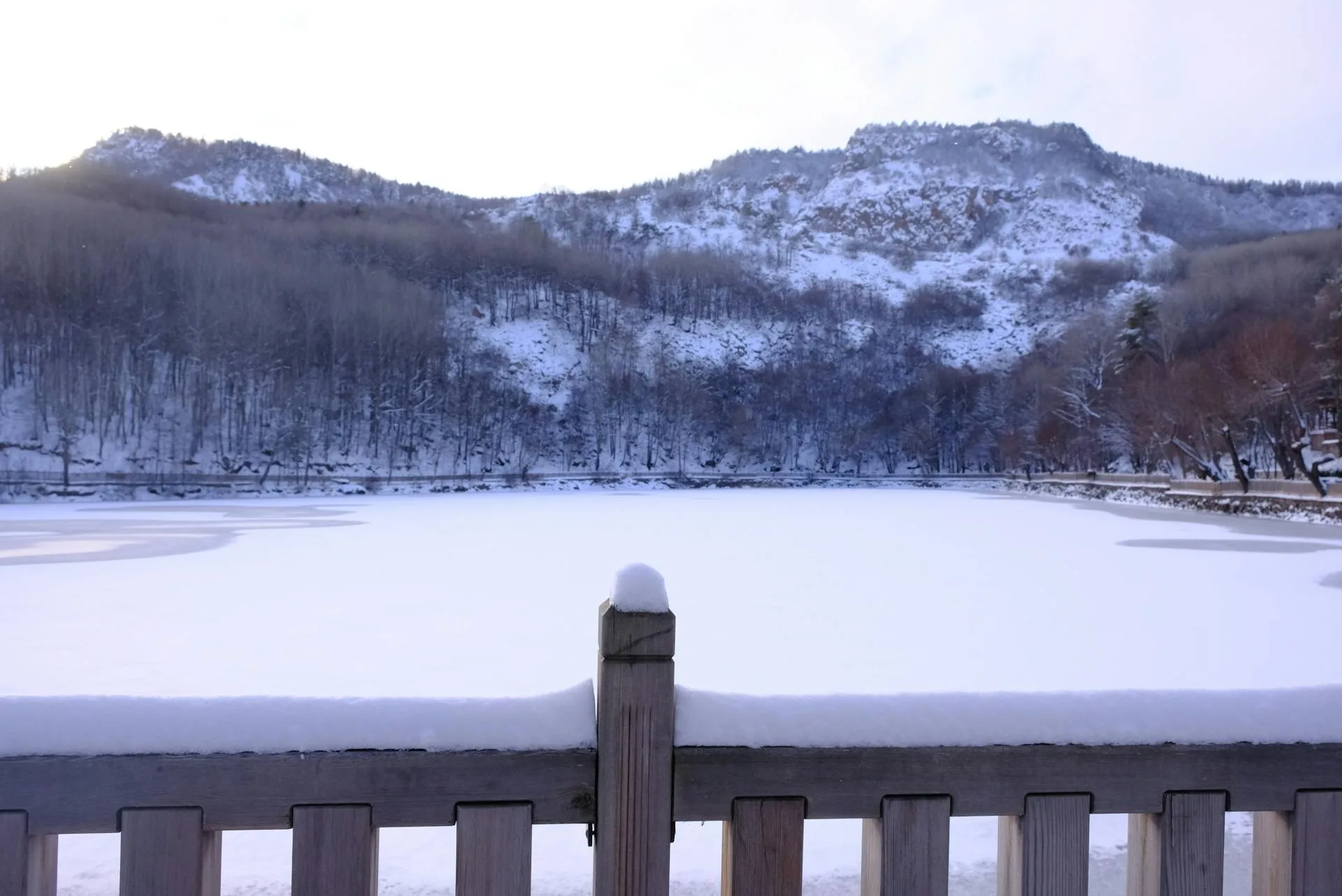 A tranquil snow-covered lake with mountain views