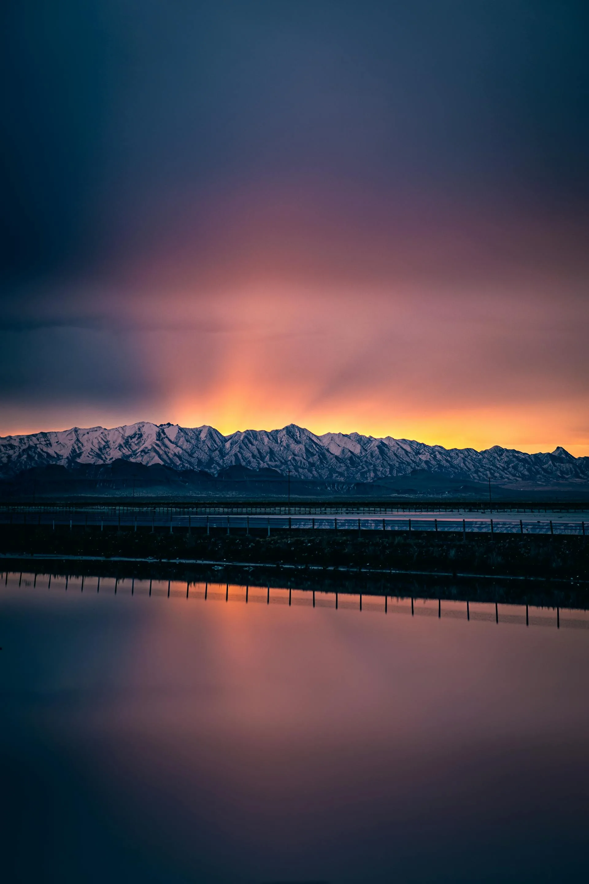 Sunset over a snow-covered mountain near a body of water