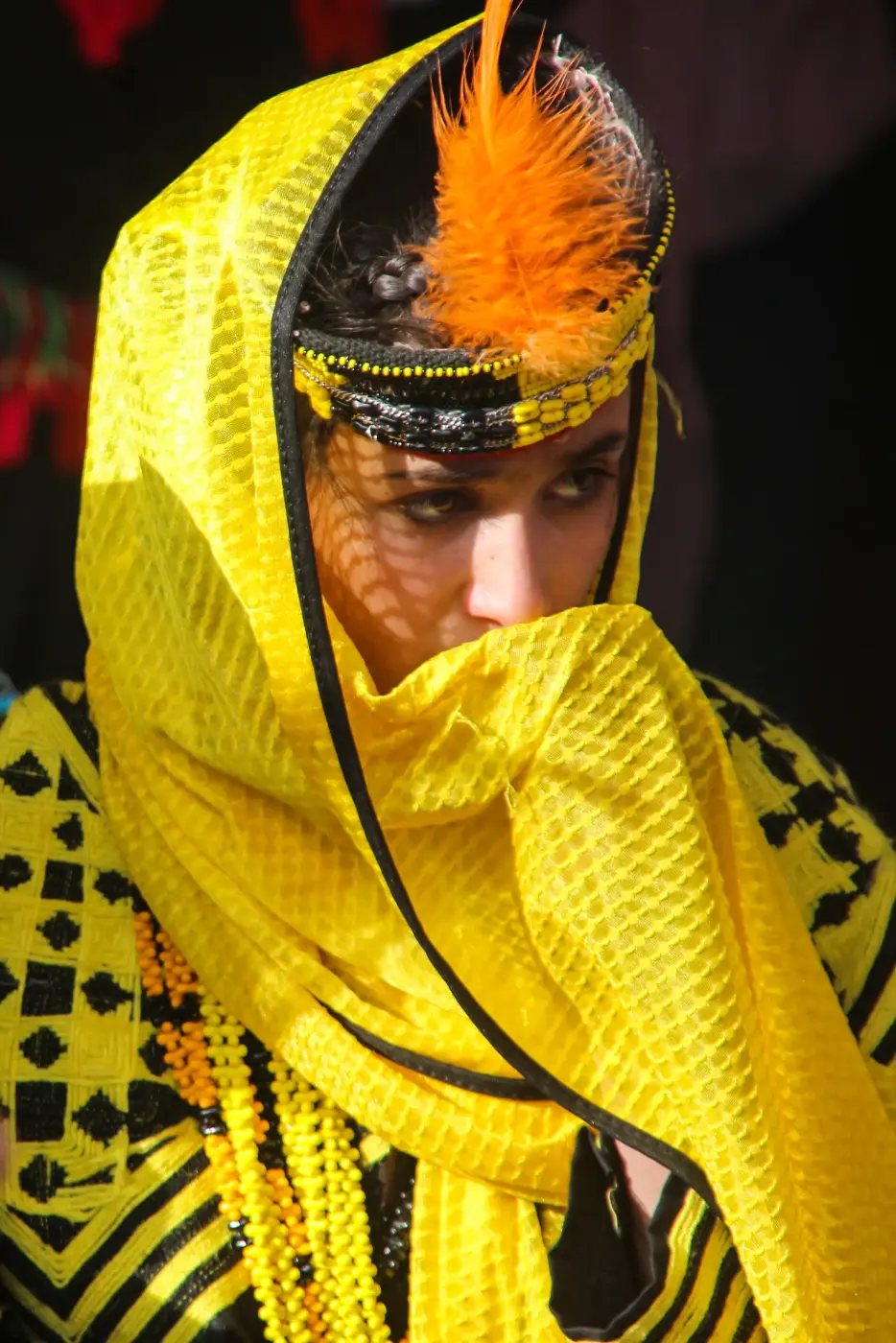 Ein Kalash-Mädchen mit Federkappe (kupas) und gelbem Schleier beim Chilam-Joshi-Frühlingsfest in Chitral