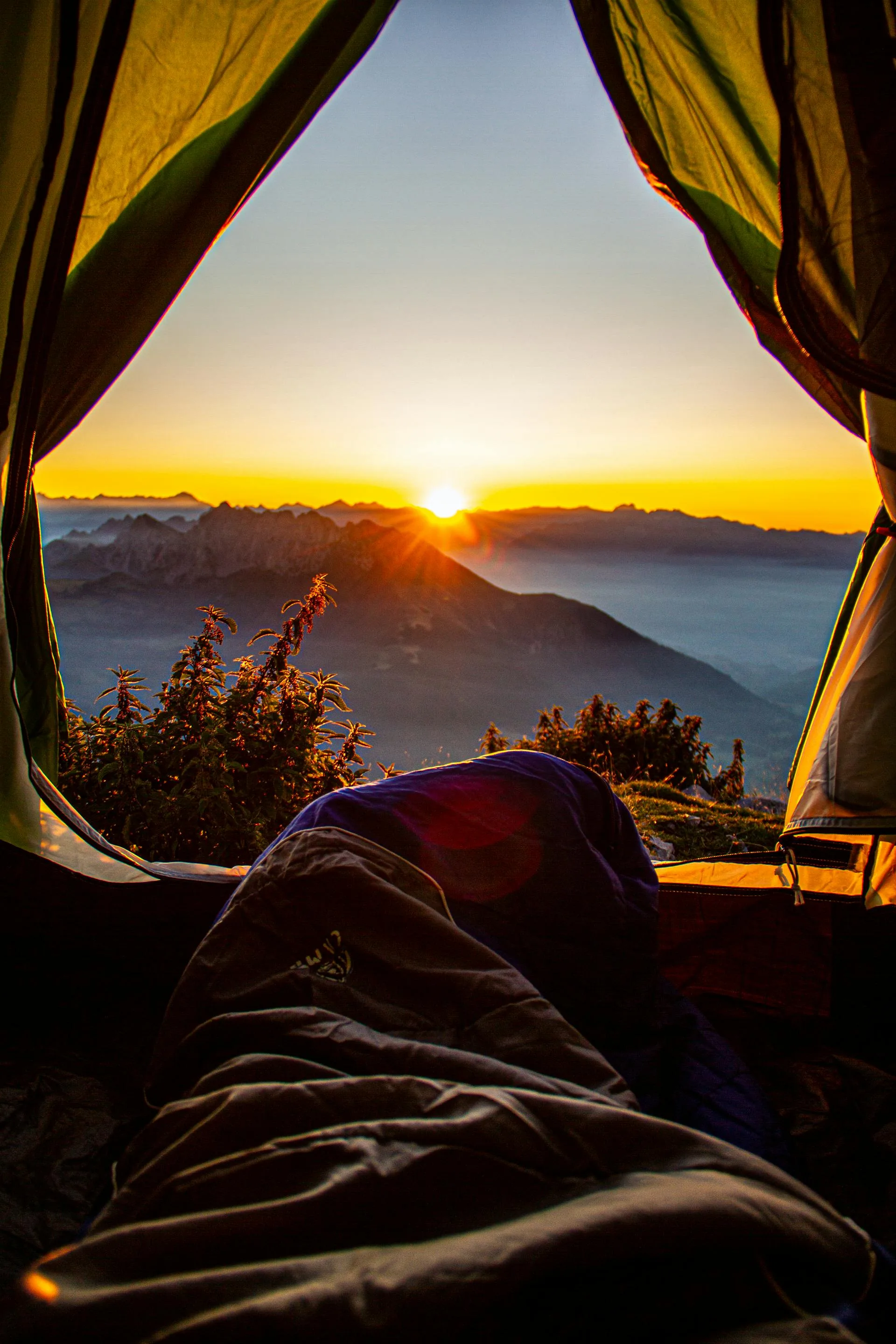 Watching sunrise from tent in mountains