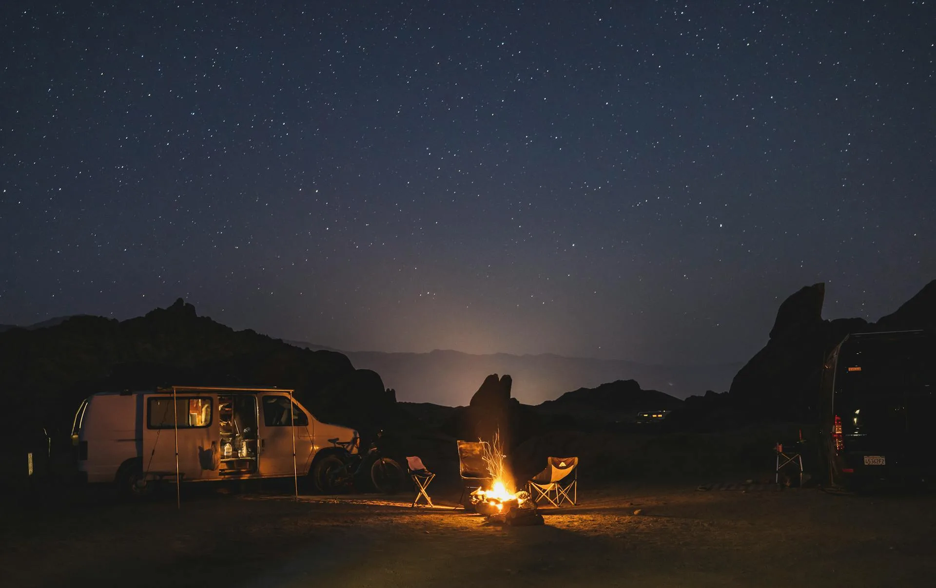 Night camping with tents and campfire under stars