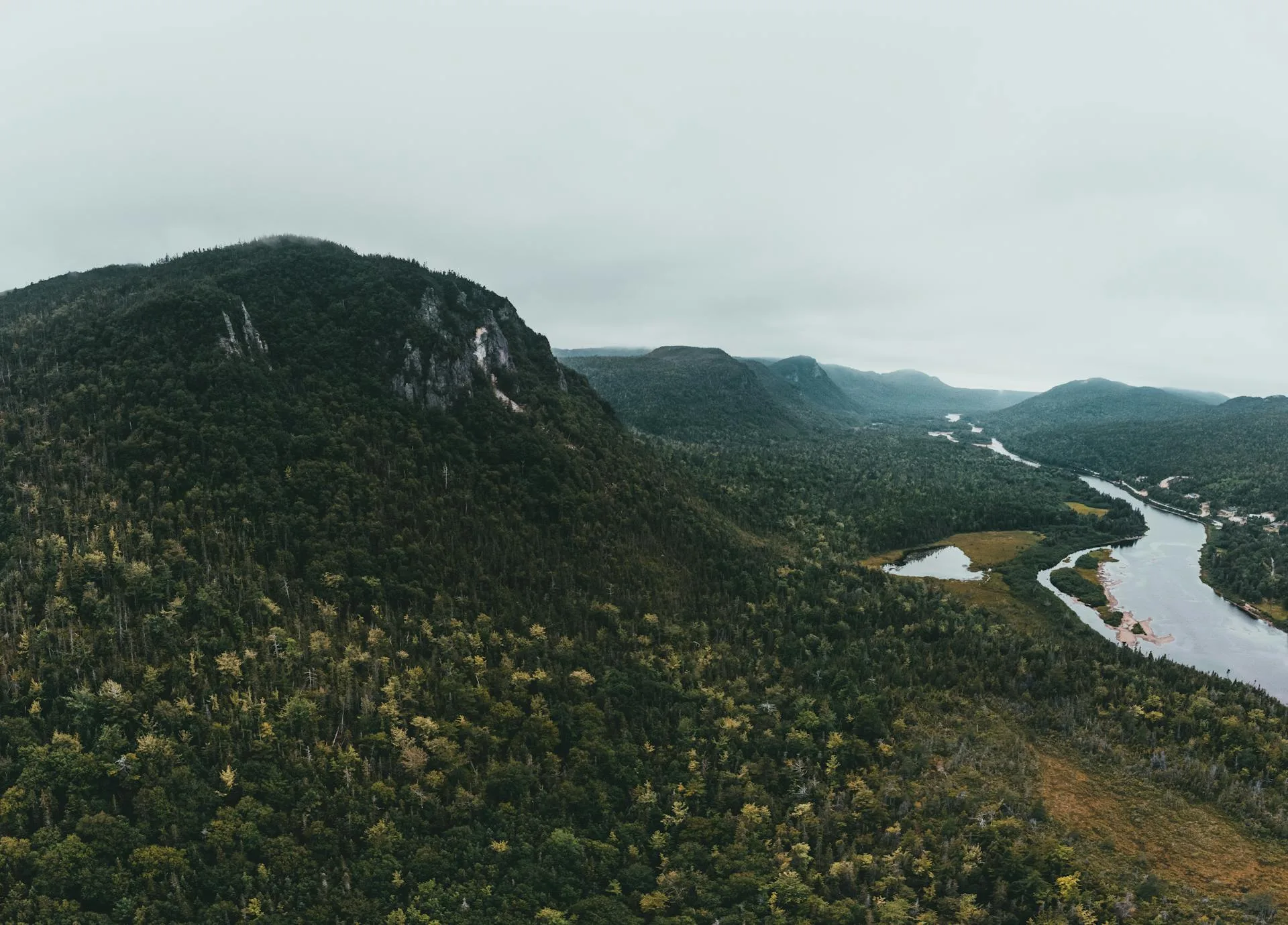 River in valley with mountain peaks in fog