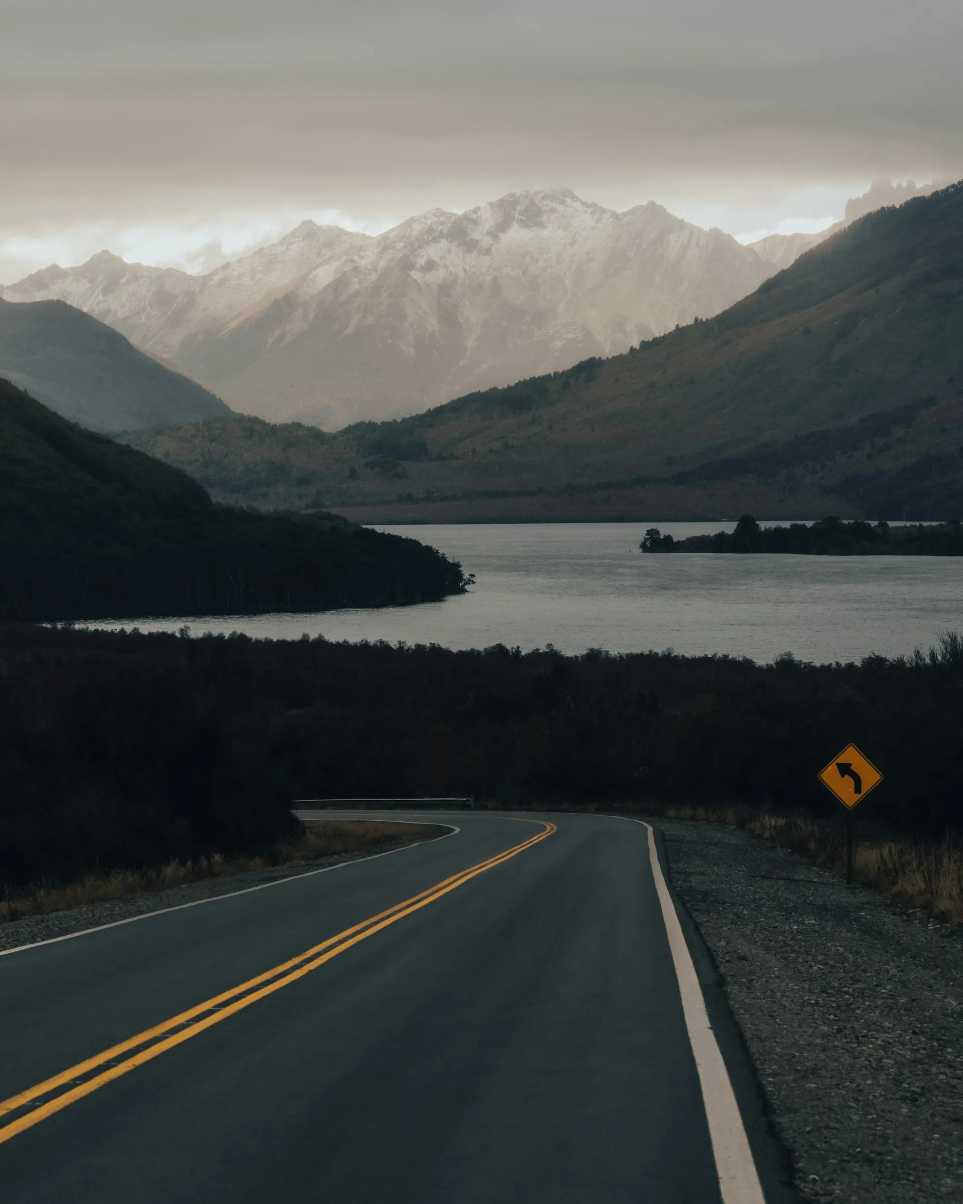 Road alongside lake with mountains