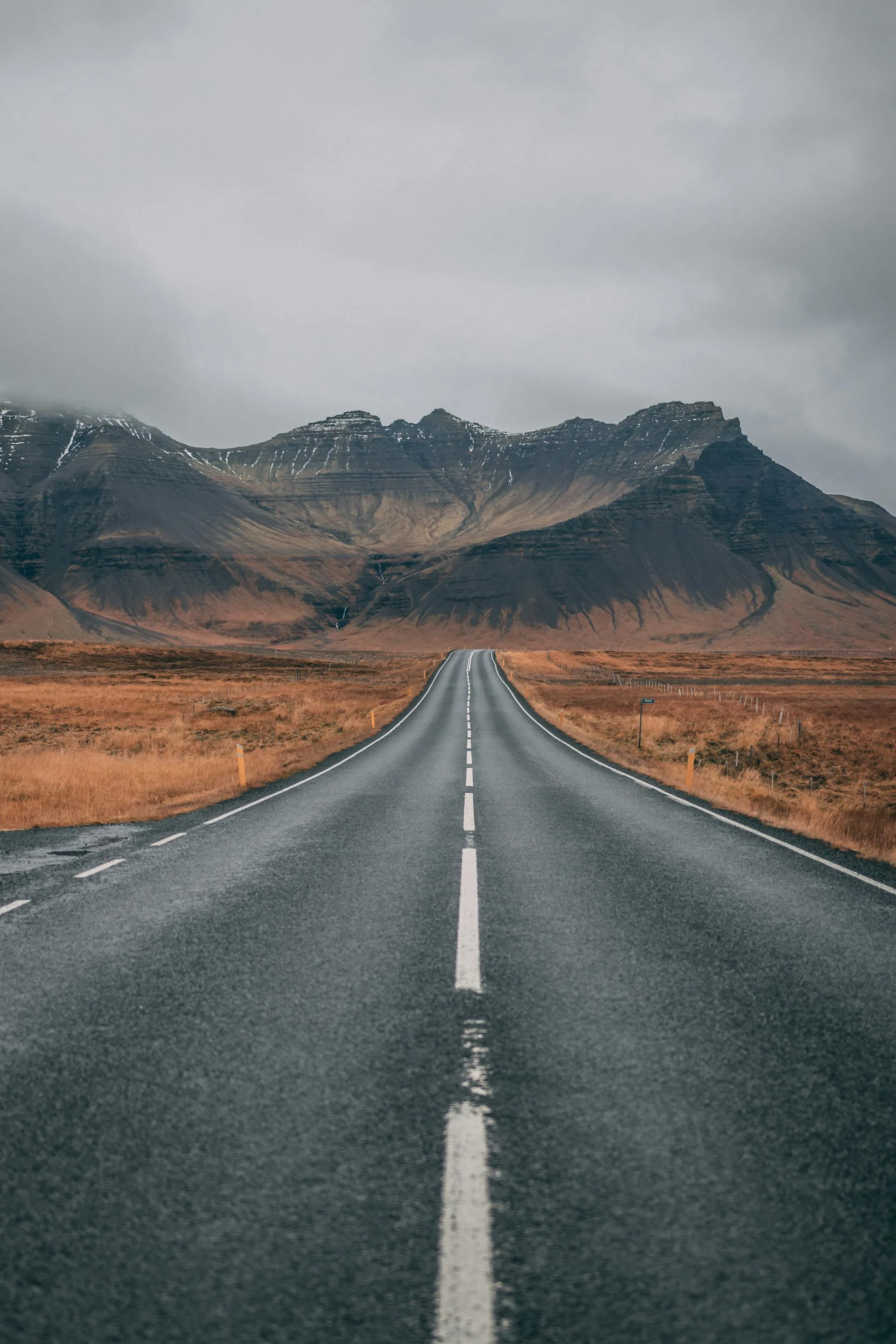 Highway overlooking mountains under dramatic skies