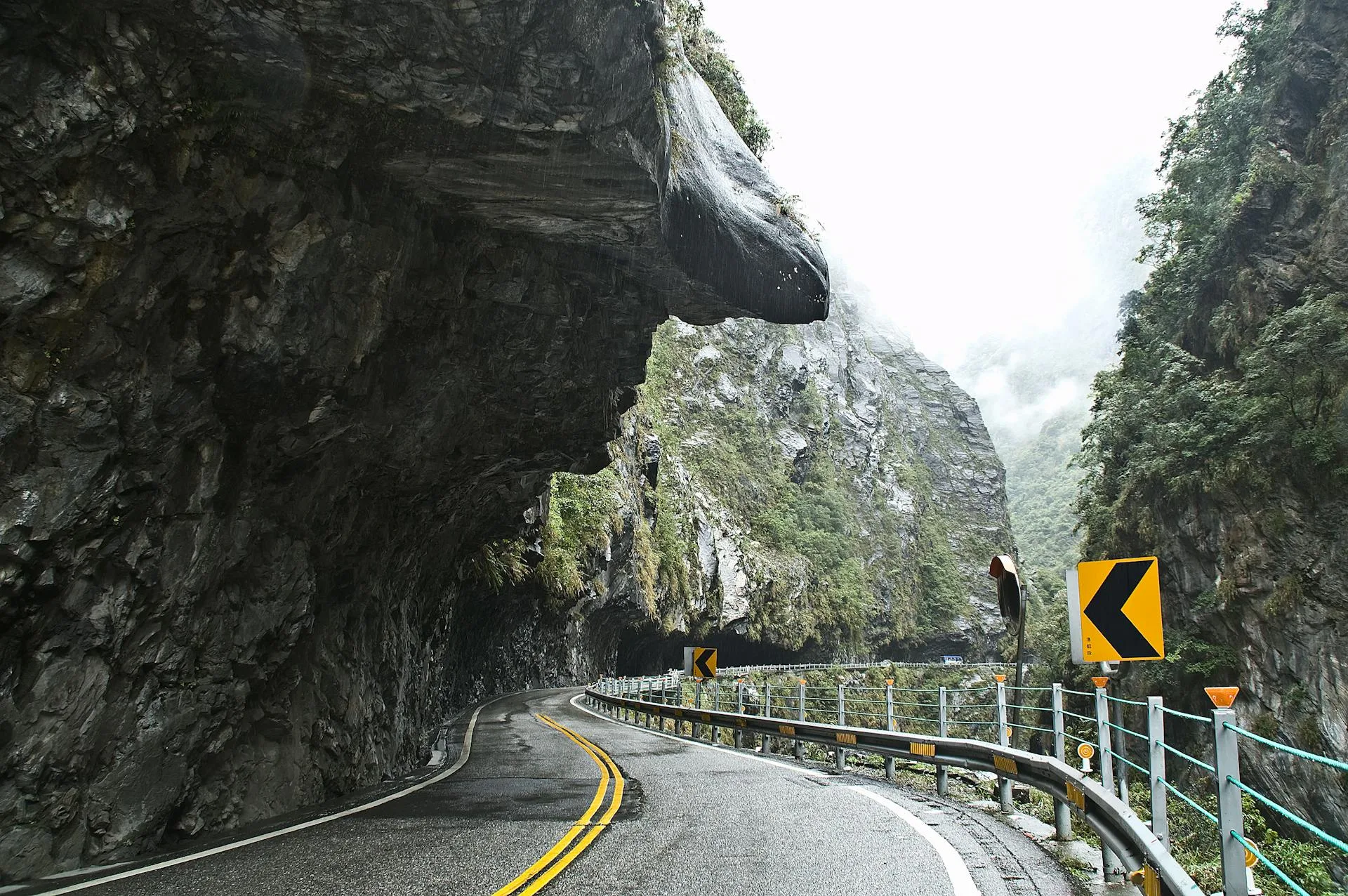 Road curve alongside steep mountain cliff