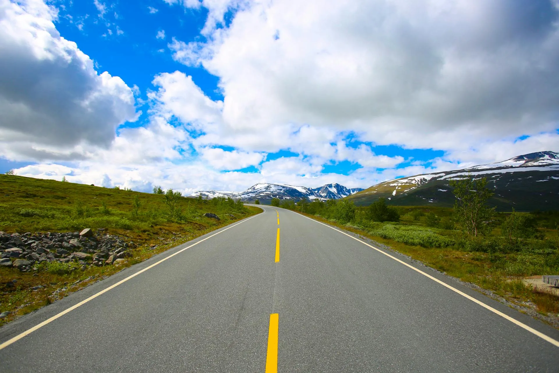 Road through green valley toward mountains