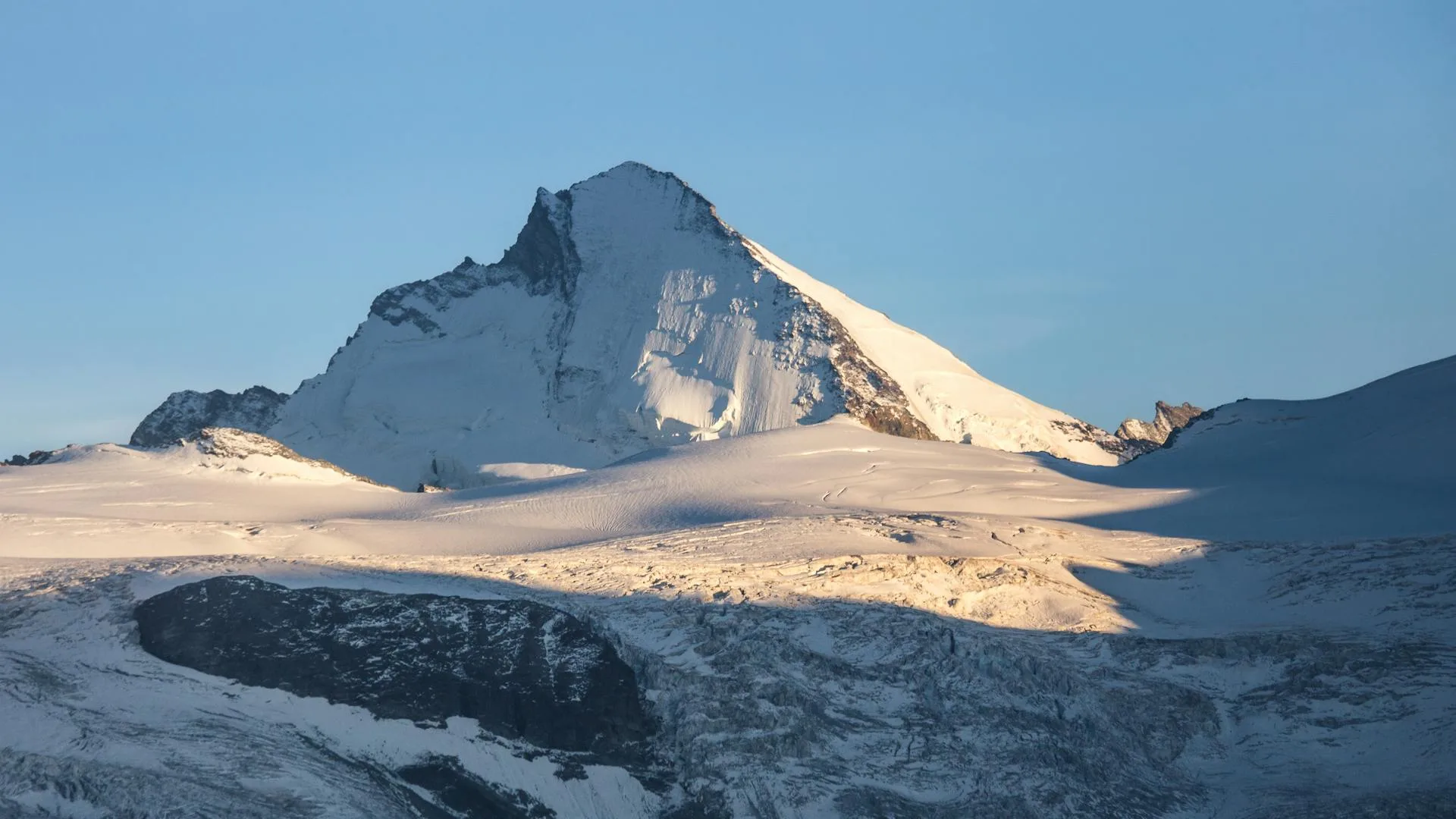 A massive snow-covered mountain peak reaching into the clouds