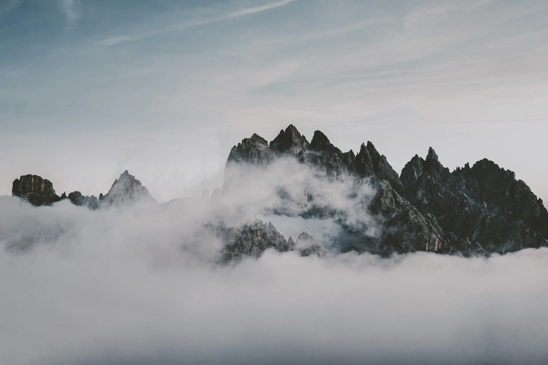 Mountain peaks rising above clouds at golden hour