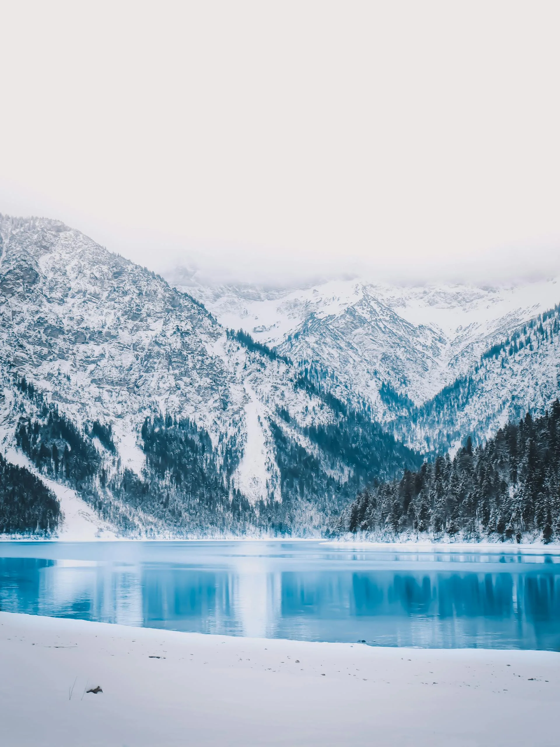 A crystal clear lake surrounded by snow-covered mountains