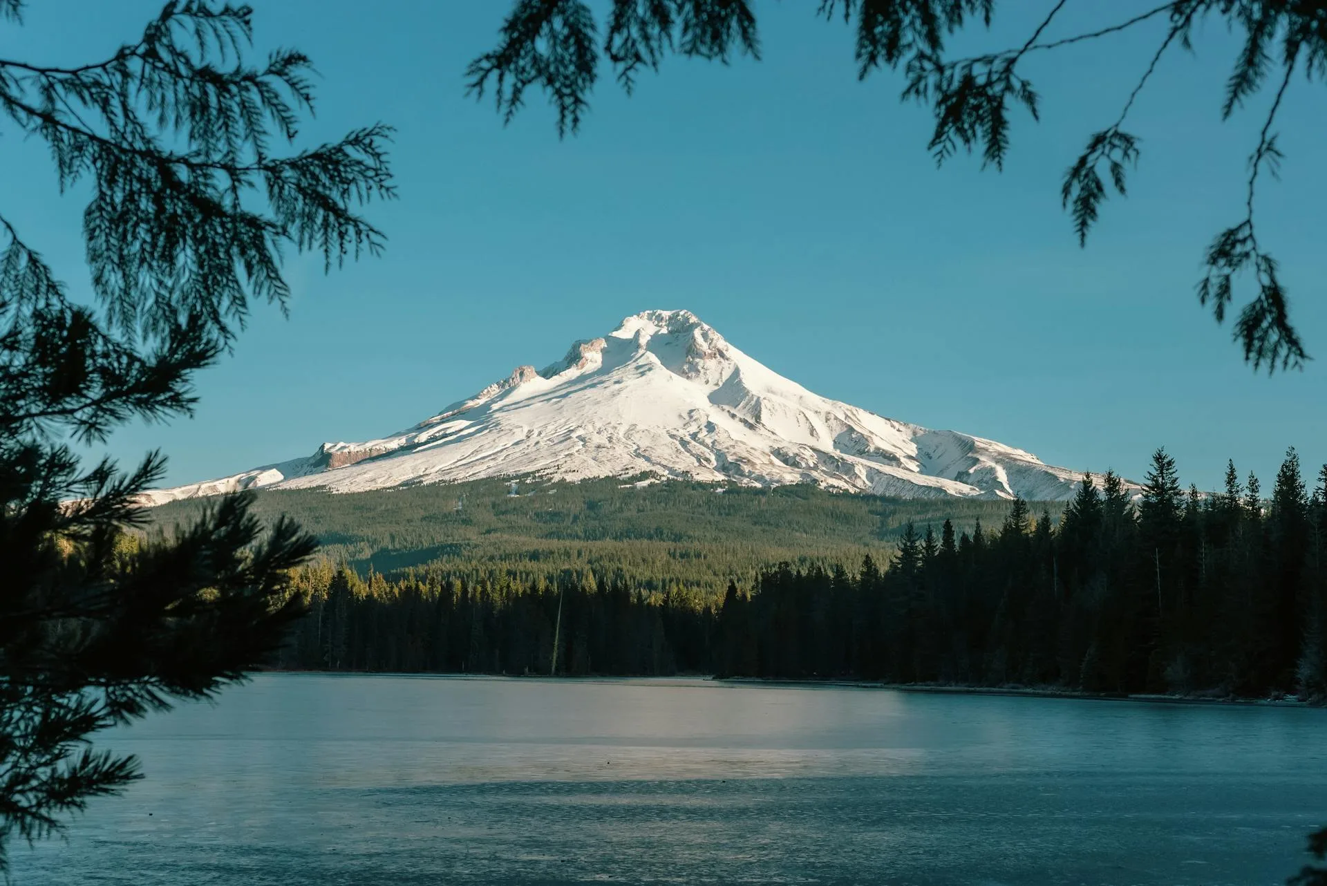 A pristine lake with a snow-capped mountain in the background