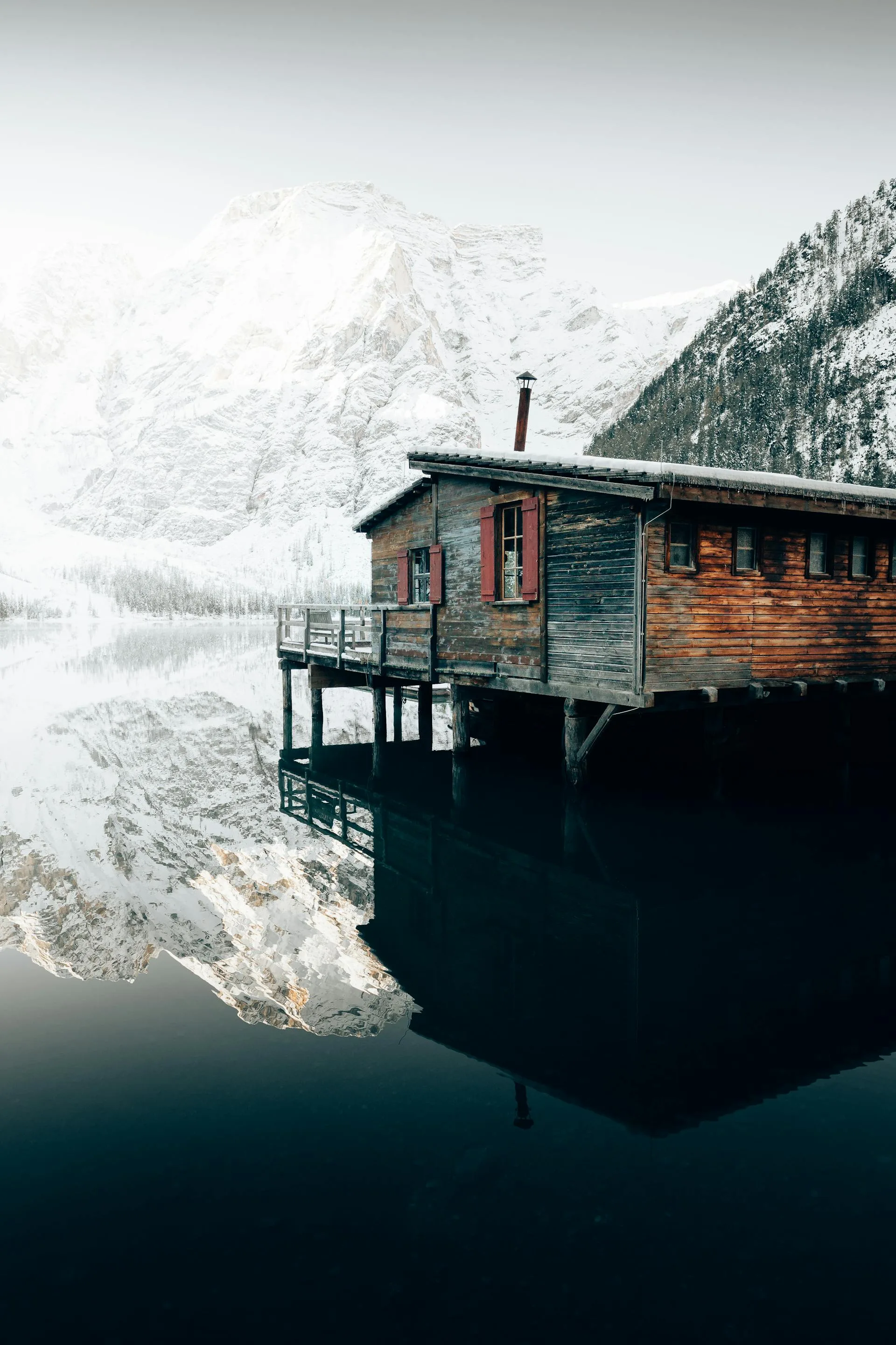 Wooden house over serene mountain lake