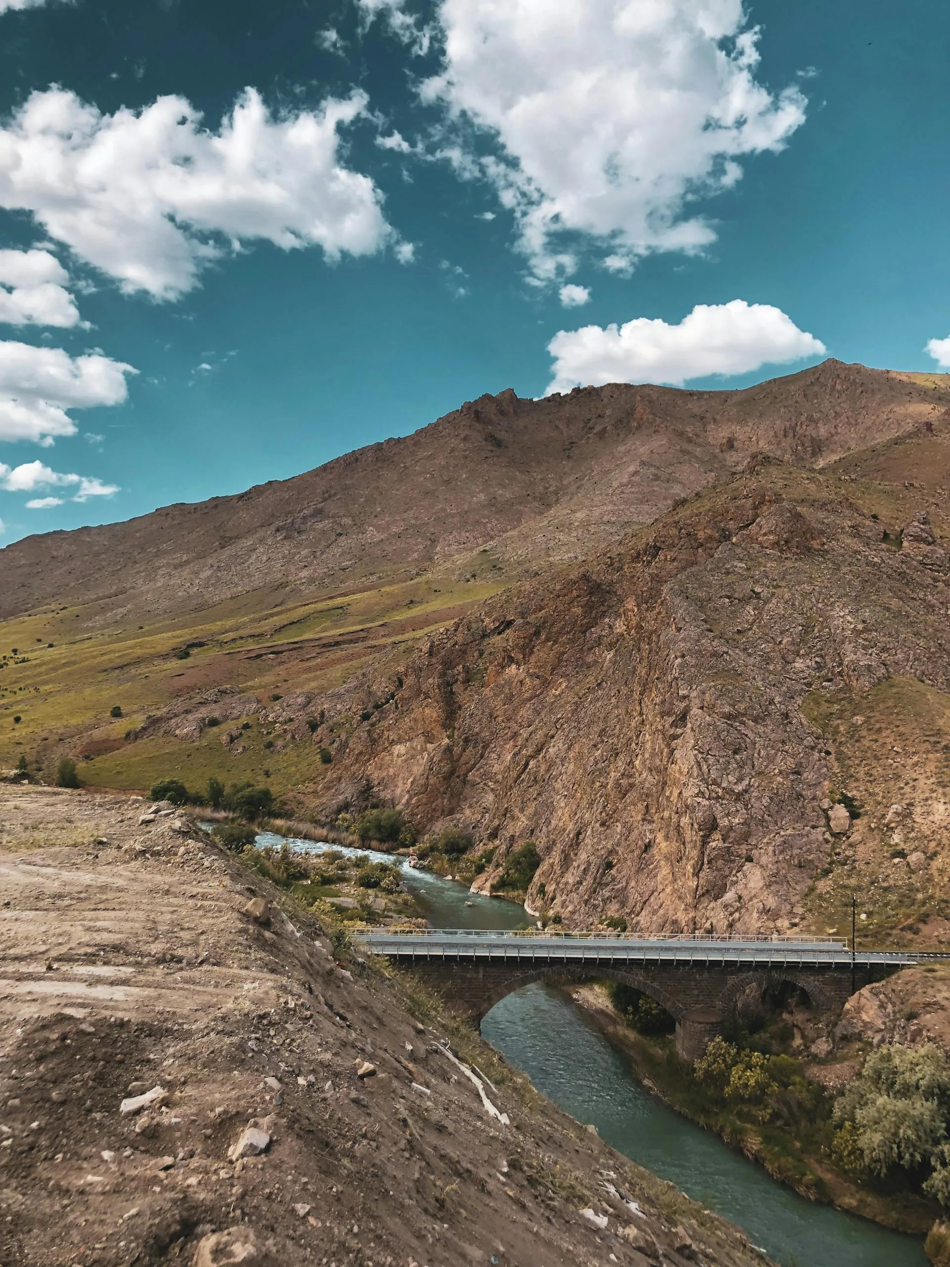 A scenic mountain landscape with a bridge and river