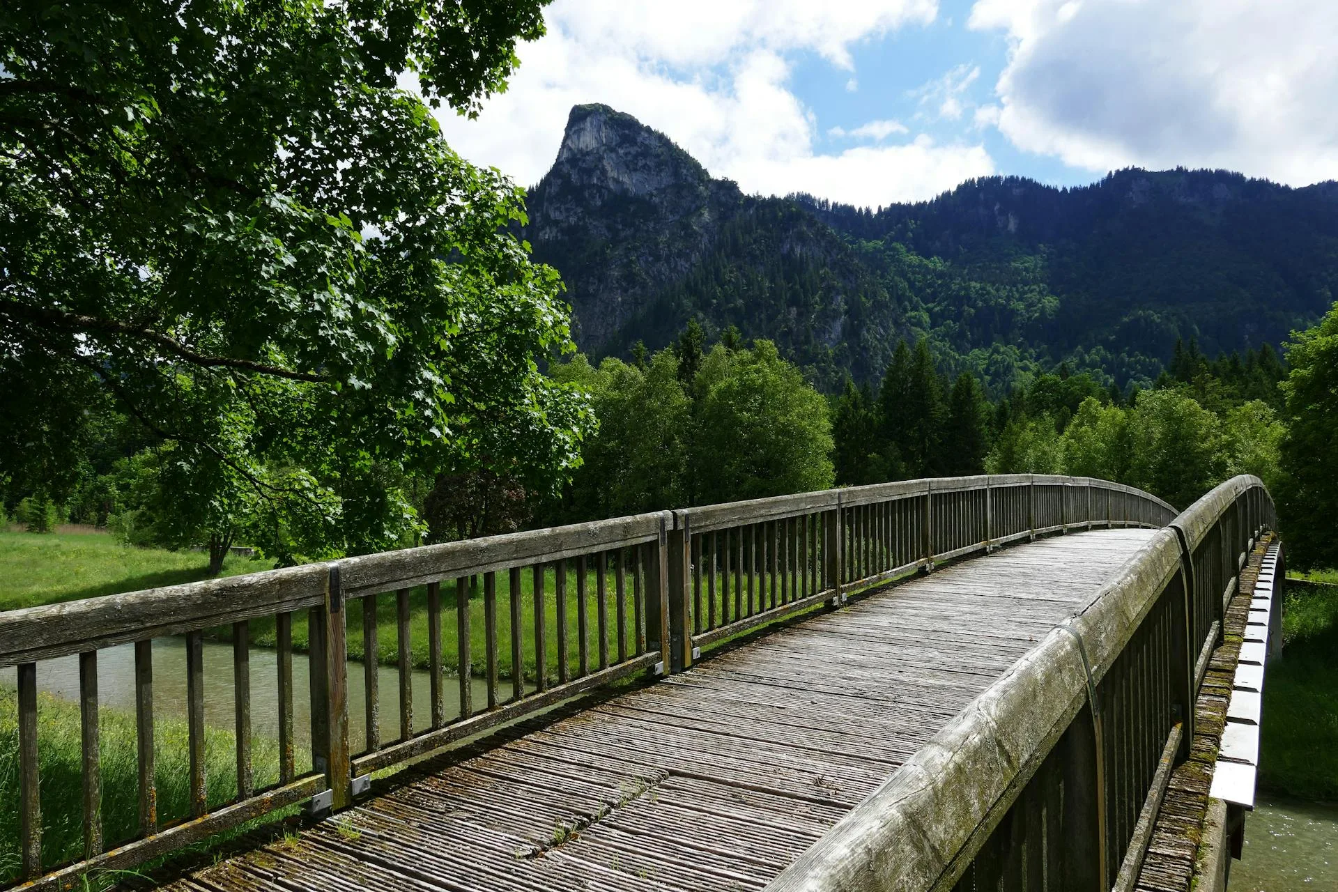 A wooden bridge near towering mountains