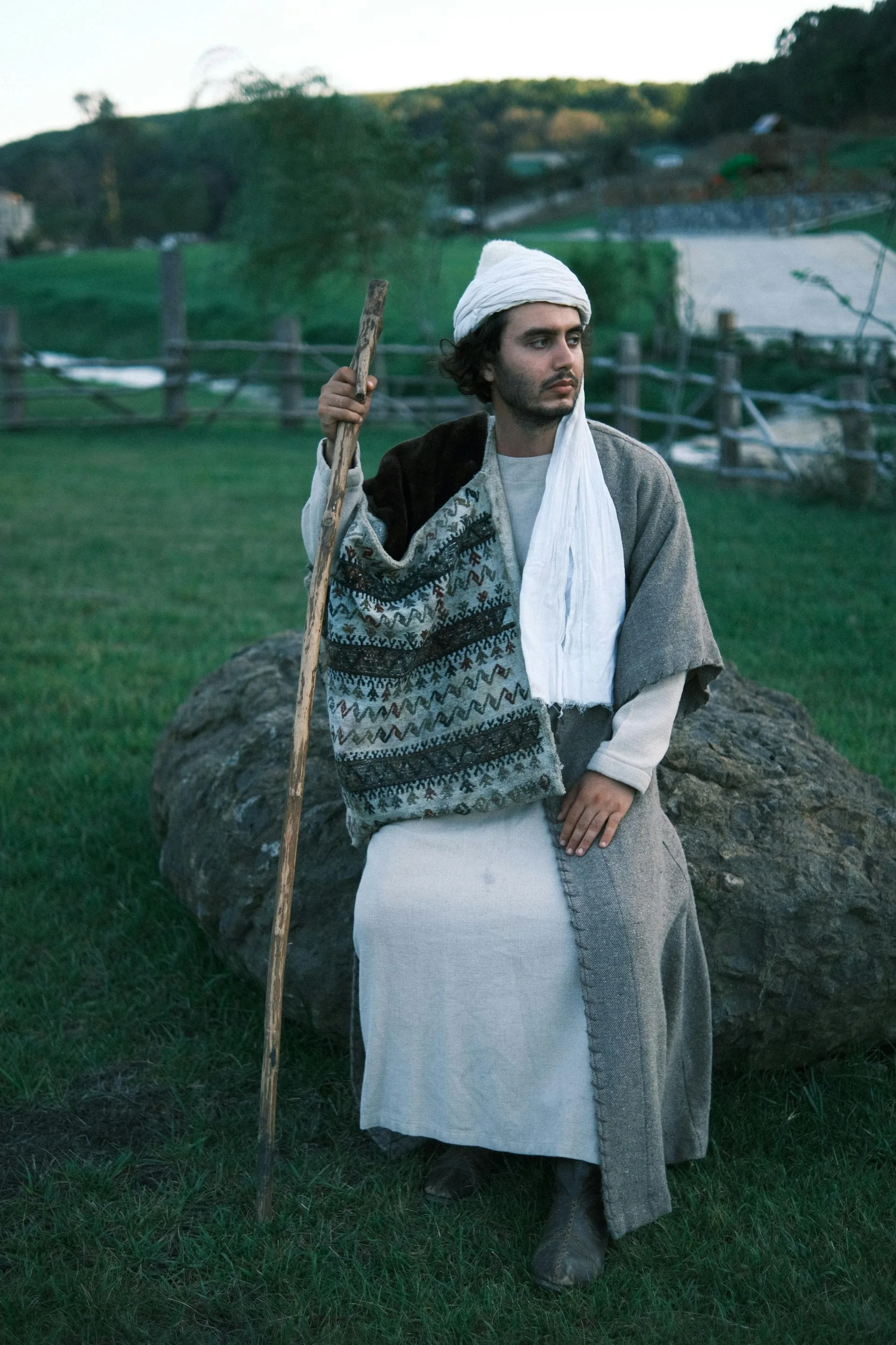 Shepherd in traditional clothing on mountain rocks
