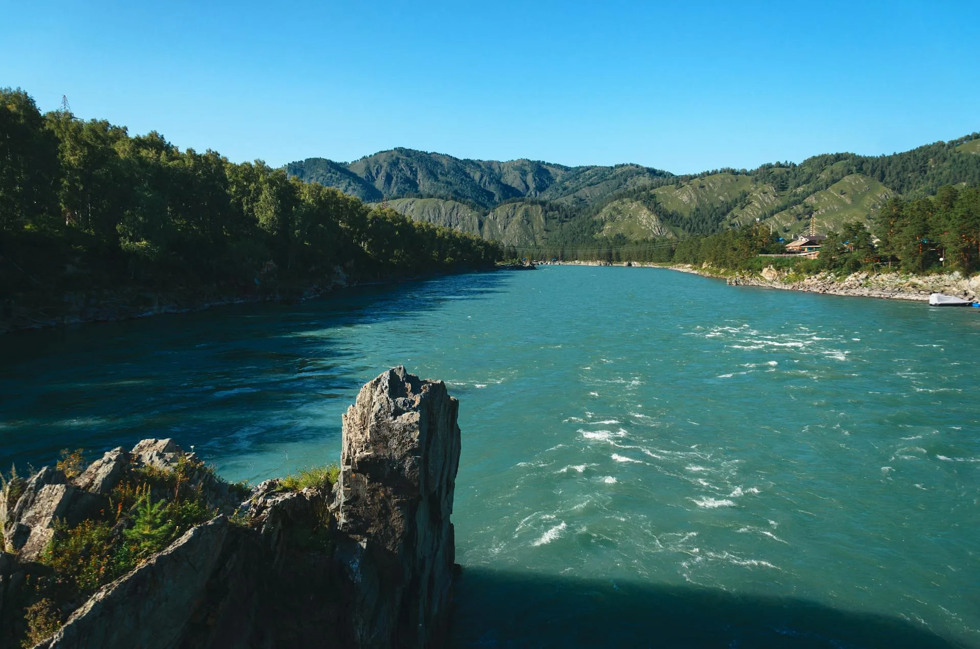 Wide flowing mountain river through valley