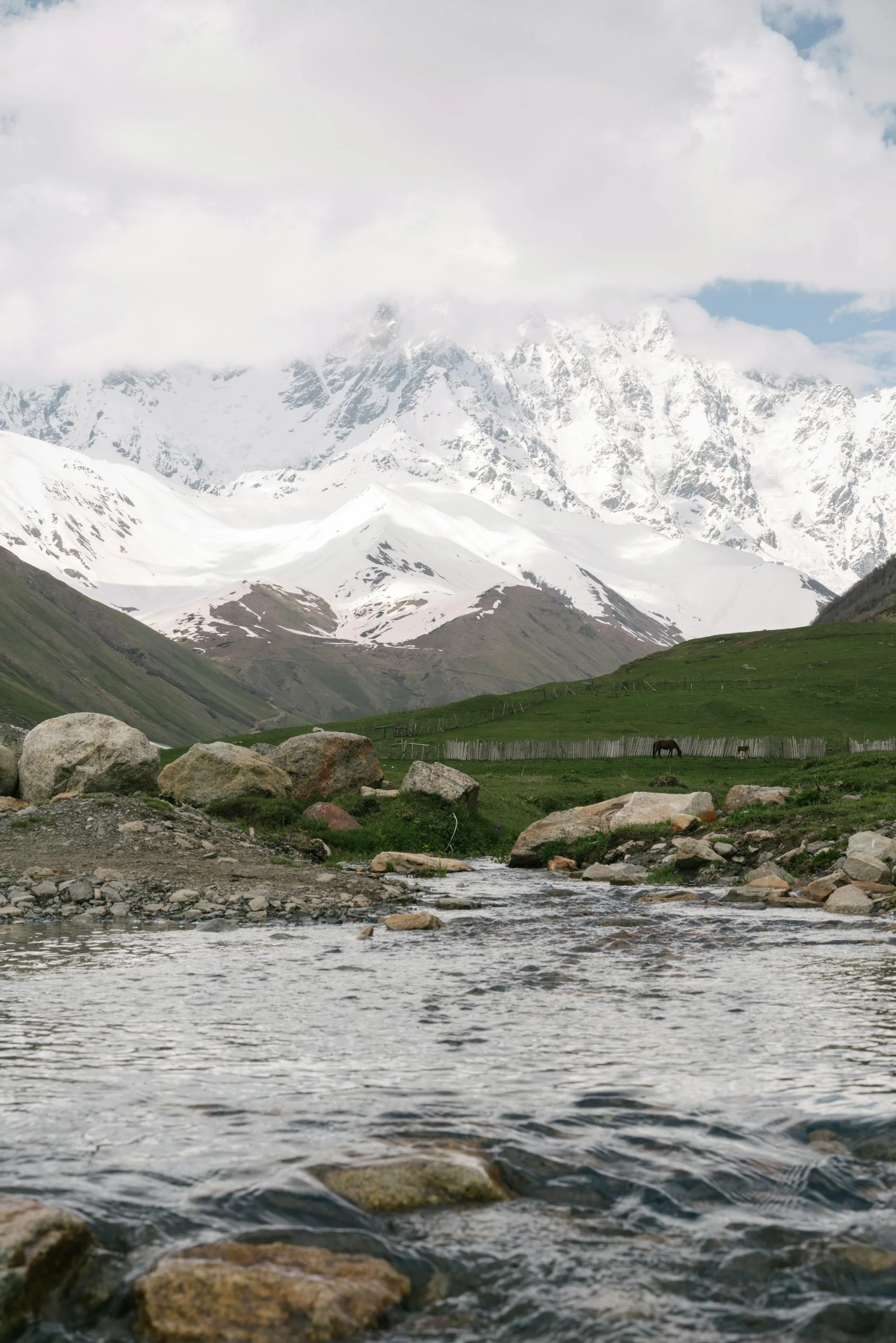 A river flowing against a snow mountain background